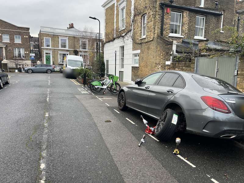 A Mercedes saloon with its wheel off on a residential street – Yellow Tyres mobile tyre repair service, covering Dagenham