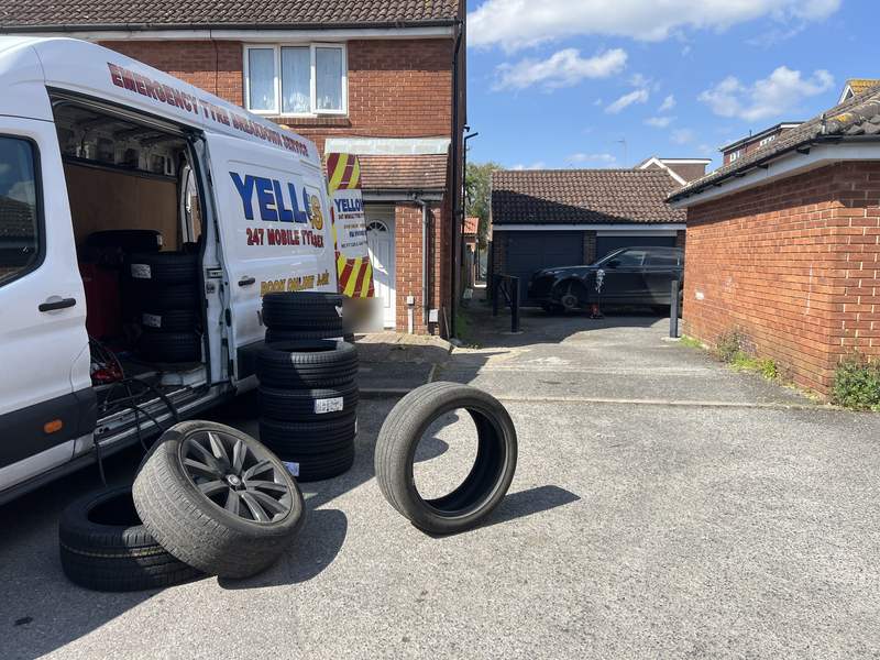 New tyres stacked by our van in a residential garage court – Yellow Tyres mobile tyre fitting prices